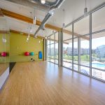 View of empty fitness room with bamboo floors and large windows.
