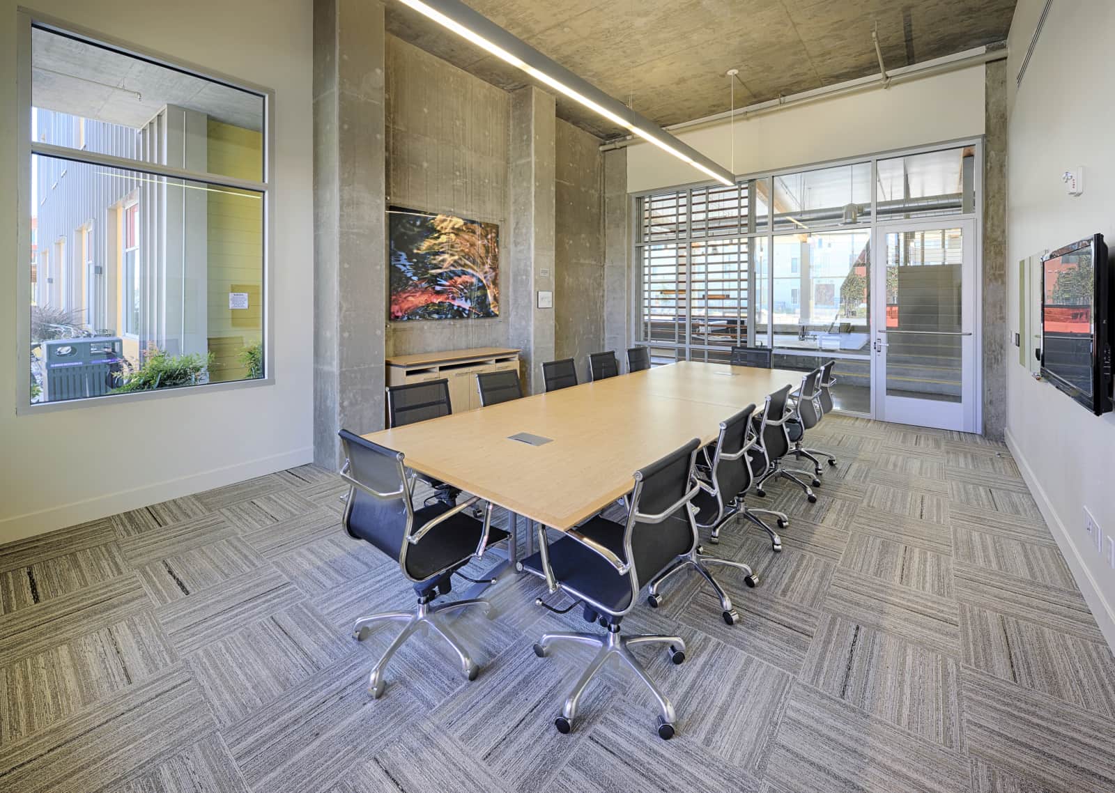 Conference room with a large table, chairs, white board and TV..