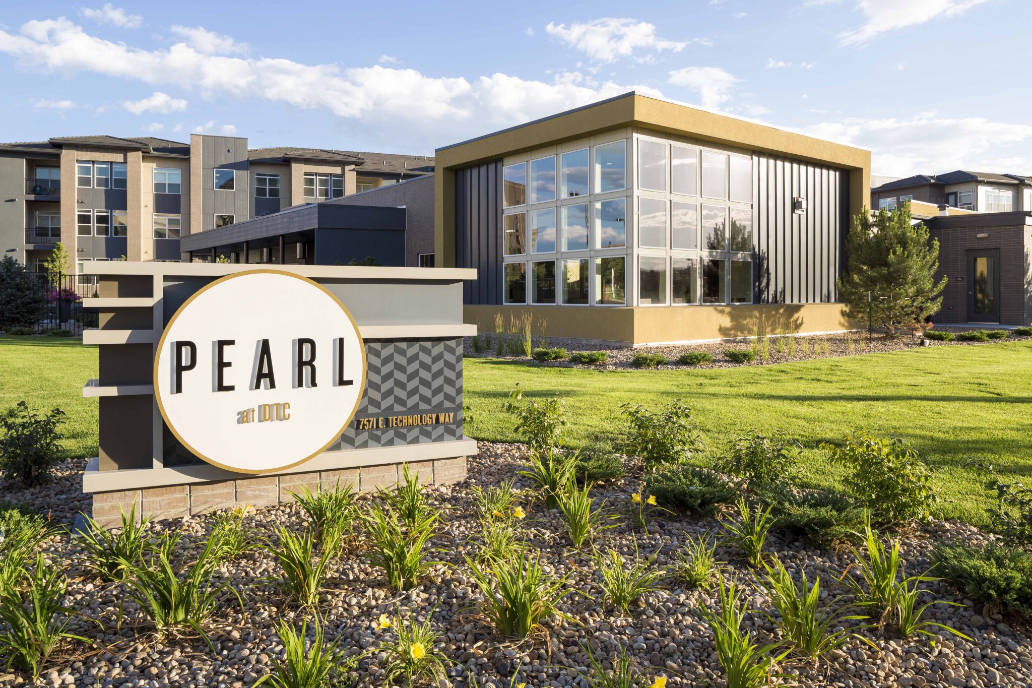 Exterior with sign for Pearl apartments with buildings in the background