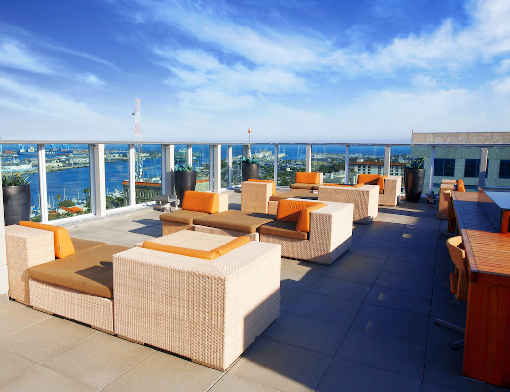 Roof deck with lounge chairs with a view of the water in the background.