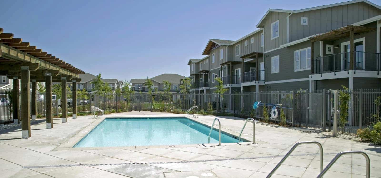 View of the pool area with the apartment buildings in the background.
