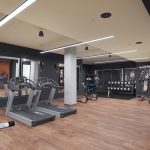Interior of modern fitness room with exercise machines and weights